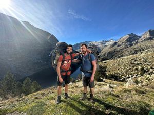 The two hikers standing with backpacks under a blue sky