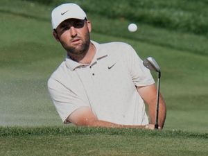 Scottie Scheffler plays out of a bunker