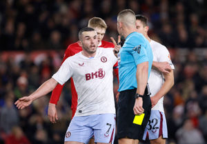 Referee Robert Jones gestures to Aston Villa's John McGinn