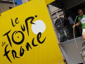 Mark Cavendish walks towards a Tour de France sign