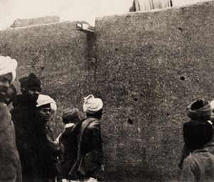 Locals inspecting bullet-holes in the southern wall, behind the shrine, in late 1919