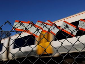 Train tickets placed in a fence in front of a train passing through Ashford in Kent