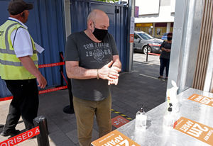 A customer sanitizes his hands on entry