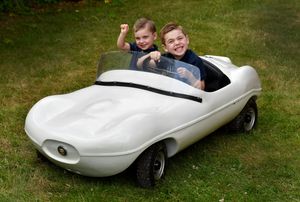 Jude Loach, aged 2 and brother Adam, aged 5 trying out the 1950's model Jaguar Tiger Cub D type