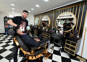 Bako Ahmad pictured at work in the new barber shop, which offers treatments and services alongside traditional haircuts