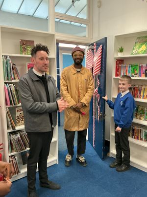 Claregate Primary School headteacher Lee Davis-Powell introduces actor Omari Douglas to pupils at the unveiling of the school's new library