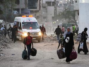 Palestinians walking while carrying bags after an Israeli evacuation warning in an area of Gaza City