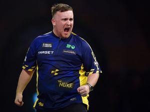 Luke Littler celebrates on the Alexandra Palace stage