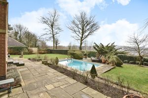 The outdoor heated pool sits amid manicured lawns and a patio