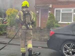 A firefighter moves towards the house.