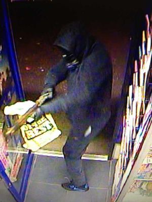 The gunman points his weapon in the shop doorway