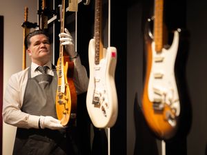 An art handler holds a 1959 Gibson Les Paul known as Yardburst during the photocall for the Jeff Beck: The Guitar Collection at Christie’s in central London