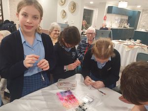 Children from Moreton Hall Primary School at HC-One’s Bluebell View Care Home with residents making friendship bracelets