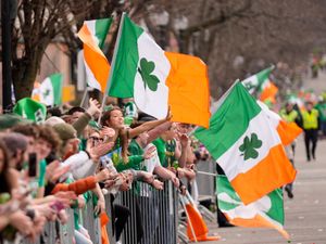 People waving flags at a St Patrick’s Day Parade