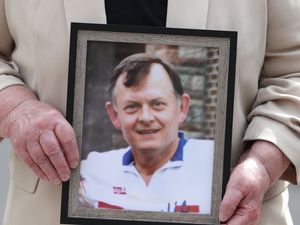 Bridie Brown, the widow of murdered GAA official Sean Brown, holds a picture of him, outside the Royal Courts of Justice in Belfast