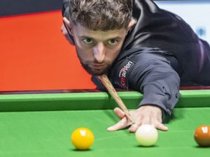 Joe O'Connor cues a shot against John Higgins at the Crucible