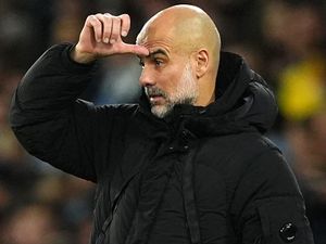 Pep Guardiola scratches his forehead with his finger