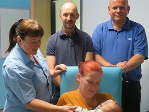 Sarah and Mike Clifford and their baby son Logan – with porters Ruth Lowe, left, and Nick Evans, far right