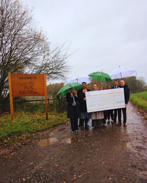 Walton Homes presents the cheque to the Kids' Village team