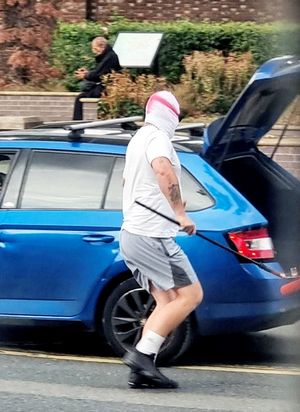 Two men wearing St George's masks have been captured on camera painting England flags on roundabouts and zebra crossings across a town. 