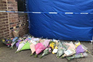 Some of the floral tributes next to a forensic tent on Greyhound Lane on Friday morning