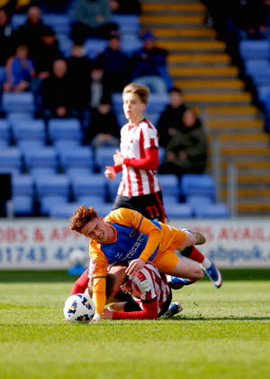 Tommy McDermott of Shrewsbury Town is brought down