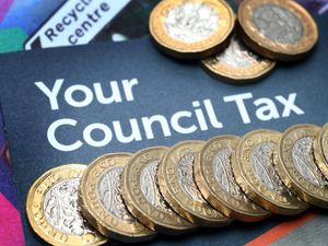 A council tax leaflet with a row a one-pound coins