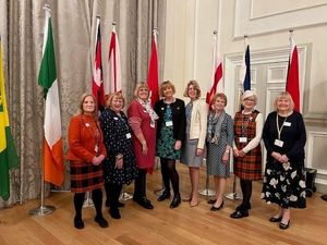 Members of SI Cannock & District in front of the flags of many of the nations in SIGBI