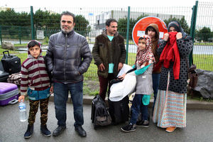 Naqeebullah Noorzada (left) accompanied by his family prepares to board a coach and leave the jungle migrant camp in Calais, France, to start a new life in southern France as plans are made to demolish the camp over the next few weeks
