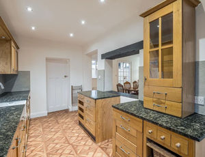 The kitchen features granite style worktops and a rustic feel