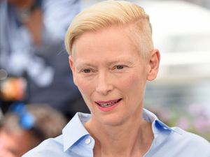 Headshot of Tilda Swinton in blue shirt