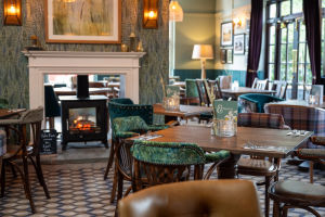 Cosy dining area inside Himley House pub with patterned floors, soft lighting, and a log-burning stove
