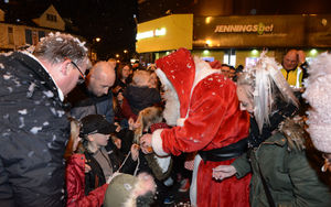 Father Christmas hands out treats to children.