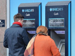 People withdrawing cash at a Barclays ATM machine