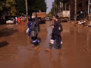 Two women walk in the mud after floods in Catarroja on the outskirts of Valencia, Spain