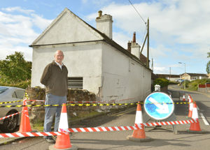 Neil Owen outside his damaged house