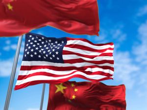 US and China flags against blue sky