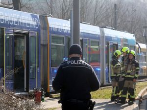 Police and firefighters stand outside a tram