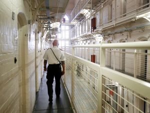 Prison officer walking through prison wing