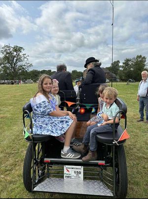 Ambassador Nerys Powel with attendants on a carriage on the showground