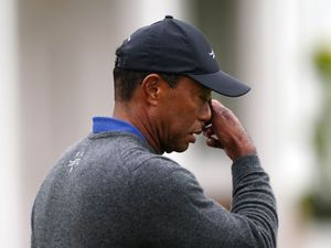 Tiger Woods wipes his face