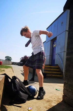 Oliver Heaton playing football in his school skirt