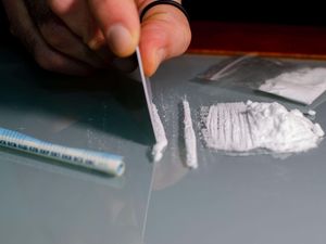 A man divides cocaine into lines. Nathias Douglas was sentenced at Shrewsbury Crown Court for supplying drugs. He fled police in Telford before being found with wraps in his possession.