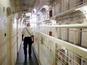 A prison officer patrolling a wing in a jail