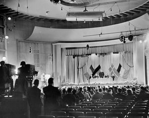 The only information to accompany this photo is 'Wolverhampton Civic Hall (Wulfrun Hall) Television Jan 1955.' The flags may indicate some sort of international flavour to what was being filmed.