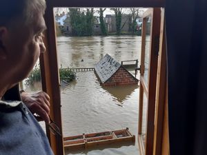 Terry Roberts looks out on his riverside back garden where the water was up to the roof of his shed and submerged his bird feeder
