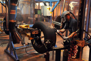 A worker inside the Goodyear factory in 2013: The old tread is worn down and any defects in the rubber removed and repaired