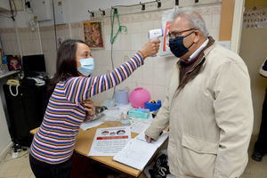 Belvant Patel takes the temperature of Kantilal T Patel on the entrance to the temple