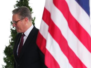 Sir Keir Starmer walks past an American flag at the White House