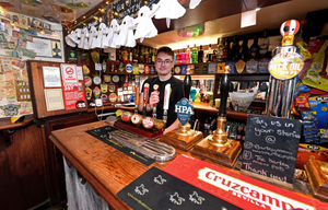 Layton Williams helps to pour the pints behind the bar